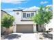 Charming two-story home with a two-car garage and well-manicured landscaping under a blue sky at 1703 Game Garden Rd, North Las Vegas, NV 89031