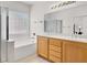 Well lit bathroom featuring a tub, shower, double sink vanity, and plenty of natural light at 209 Prairie Creek St, Henderson, NV 89012