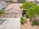 Charming desert home featuring a two-car garage, well-maintained landscaping, and a welcoming entrance at 209 Prairie Creek St, Henderson, NV 89012