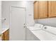 Functional laundry room with washer, dryer, and overhead cabinets for storage at 209 Prairie Creek St, Henderson, NV 89012