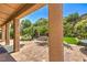 A covered patio overlooking a landscaped backyard with lush greenery and trees at 2189 De Narvik Dr, Henderson, NV 89044