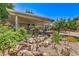 Lush backyard featuring a rock waterfall, covered patio, and well-maintained landscaping at 2189 De Narvik Dr, Henderson, NV 89044