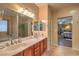 Bathroom with double sinks, large mirror, and a shower visible in the mirror's reflection at 2189 De Narvik Dr, Henderson, NV 89044