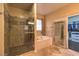 Modern bathroom featuring glass shower, soaking tub, and a view into a closet at 2189 De Narvik Dr, Henderson, NV 89044