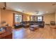 Living room with hardwood floors, a brown leather sectional, and large windows at 2189 De Narvik Dr, Henderson, NV 89044
