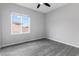 Neutral bedroom with a ceiling fan, window, and wood-look flooring at 2231 Desert Prairie St, Las Vegas, NV 89135