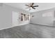 Bright living room with wood floors, ceiling fan, and large windows overlooking the backyard at 2231 Desert Prairie St, Las Vegas, NV 89135