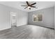 Spacious primary bedroom with a ceiling fan, large windows, and wood-look flooring at 2231 Desert Prairie St, Las Vegas, NV 89135