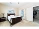 Bright bedroom featuring a dark wood bed frame, neutral walls, and access to a walk-in closet and bathroom at 2326 Garnet Star St, Henderson, NV 89044