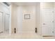 Neutral hallway featuring tile flooring, artwork, and multiple doorways at 2326 Garnet Star St, Henderson, NV 89044