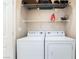 Convenient laundry area with a side-by-side washer and dryer, as well as wire shelving for storage at 2326 Garnet Star St, Henderson, NV 89044
