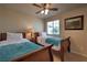 Cozy bedroom with twin beds, ceiling fan, window, and neutral paint at 2373 Rue Royale St, Henderson, NV 89044