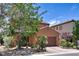 View of a two-story home with a brick driveway and landscaped front yard and desert landscaping at 2373 Rue Royale St, Henderson, NV 89044