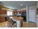 Modern kitchen featuring wood cabinets, tile floor, granite countertops, and an island with bar seating at 2373 Rue Royale St, Henderson, NV 89044