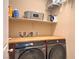 A neatly organized laundry room features a butcher block countertop, shelving, and front-load washer/dryer at 2373 Rue Royale St, Henderson, NV 89044