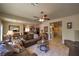 Cozy living room with neutral walls, tile flooring, ceiling fan, and an open layout to the dining area at 2373 Rue Royale St, Henderson, NV 89044