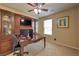Home office with custom wood built-ins, desk, ceiling fan and natural light at 2373 Rue Royale St, Henderson, NV 89044