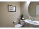 A clean powder room has neutral paint, a modern vanity and a round mirror at 2373 Rue Royale St, Henderson, NV 89044