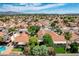 An aerial view of a suburban neighborhood with homes, mature trees, green lawns, and community amenities at 2412 Muirfield Ave, Henderson, NV 89074