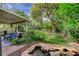 This backyard features a calming koi pond, a covered patio, and a green lawn area, perfect for outdoor enjoyment at 2412 Muirfield Ave, Henderson, NV 89074