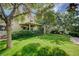 Large backyard with a covered patio, mature trees, and green lawn at 2412 Muirfield Ave, Henderson, NV 89074