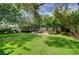Large backyard with a stone patio dining area and mature landscaping at 2412 Muirfield Ave, Henderson, NV 89074