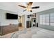 Spacious bedroom with a ceiling fan, mounted TV, dresser, and an adjacent bathroom creating a private suite at 2412 Muirfield Ave, Henderson, NV 89074