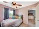 Charming bedroom showcases plush carpeting, a ceiling fan, and a comfortable bed with decorative throw pillows at 2412 Muirfield Ave, Henderson, NV 89074