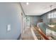 Hallway with a staircase and landing featuring stylish railing and lighting leading to the second floor bathroom at 2412 Muirfield Ave, Henderson, NV 89074