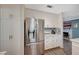Well-lit kitchen featuring stainless steel appliances, white cabinets, and views into living area with fireplace at 2412 Muirfield Ave, Henderson, NV 89074