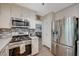 Updated kitchen features stainless steel appliances and white cabinetry at 2412 Muirfield Ave, Henderson, NV 89074