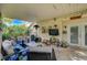 Covered patio with outdoor seating, featuring a ceiling fan, mounted television, and garden view at 2412 Muirfield Ave, Henderson, NV 89074