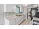 Modern kitchen featuring white cabinetry, stylish backsplash, and appliances including a black refrigerator at 2432 Spanish Ct, Las Vegas, NV 89108