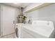This functional laundry room includes a washer, dryer, storage shelves and neutral flooring at 2432 Spanish Ct, Las Vegas, NV 89108