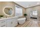 Bright bathroom with standalone tub, modern vanity, and stylish round mirror at 2714 Langlade Ave, Henderson, NV 89052