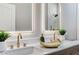 Close-up of primary bathroom double sinks with gorgeous gold fixtures and decor at 2714 Langlade Ave, Henderson, NV 89052