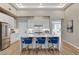 Bright open kitchen featuring white cabinets, a waterfall island with seating, and modern lighting at 2714 Langlade Ave, Henderson, NV 89052