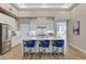 Bright kitchen features an island with blue stools and a stunning chandelier, perfect for modern living at 2714 Langlade Ave, Henderson, NV 89052