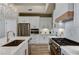 Modern kitchen with white cabinets, quartz countertops, stainless steel appliances, and a gourmet stove at 2714 Langlade Ave, Henderson, NV 89052