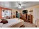 Comfortable bedroom featuring a ceiling fan, dresser with TV and an organized closet at 2725 S Nellis Blvd # 1038, Las Vegas, NV 89121