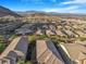 Overhead view showcasing rooftops of homes in a desert community, surrounded by mountains and open spaces at 2771 Free Formed Ct, Las Vegas, NV 89138