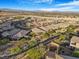 Expansive aerial view of a residential area nestled in a desert landscape, showcasing modern homes with mountain views at 2771 Free Formed Ct, Las Vegas, NV 89138