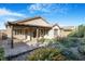 View of the covered back patio, manicured lawn, and tasteful landscaping at 2771 Free Formed Ct, Las Vegas, NV 89138
