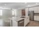 Modern kitchen featuring a stainless steel refrigerator and a spacious island with a sink at 2771 Free Formed Ct, Las Vegas, NV 89138