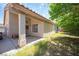 Covered back patio with stucco pillars and a spacious yard with mature trees and access to the home's interior at 2859 Palleta Dr, Henderson, NV 89074