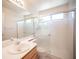 Bright bathroom featuring a glass-enclosed shower, white sink and light wood cabinet at 2859 Palleta Dr, Henderson, NV 89074
