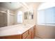 Bathroom with wooden cabinets, long mirror and shower with glass door at 2859 Palleta Dr, Henderson, NV 89074