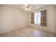 Empty bedroom with tile flooring, ceiling fan, light walls, and a window with patterned curtains at 2859 Palleta Dr, Henderson, NV 89074