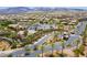 Stunning aerial view of a gated community with palm trees, a pool, and the clubhouse with mountains in the background at 2896 Grande Arch St, Henderson, NV 89044