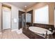 Elegant bathroom featuring a soaking tub with marble surround and a separate glass-enclosed shower at 2896 Grande Arch St, Henderson, NV 89044